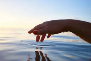 finger touching water as part of sound healing frequency
